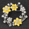 Golden yellow daffodil brooch showing detailed flower petals and tac pin fastening